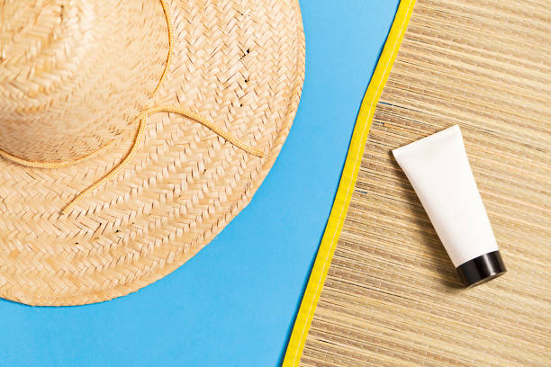 Beach mat with sunscreen and sombrero on blue background. Summer vacation concept. Sun concept.
