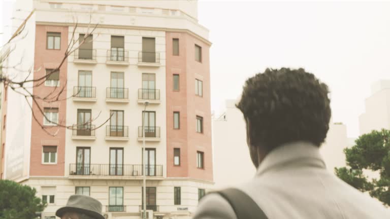 elegant black businessman traveler walking on the streets of the business district with gray coat