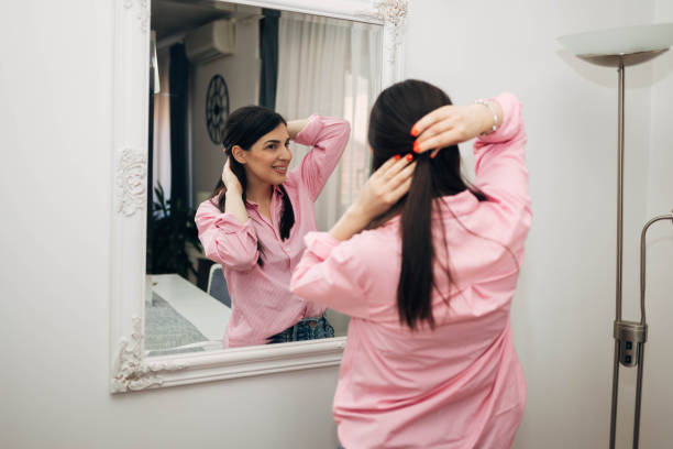 istock A beautiful woman looking at herself in the mirror. 2031174492