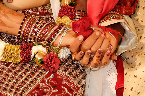 Jaipur, India - November 17, 2007: Hindu couple hands intertwined at wedding
