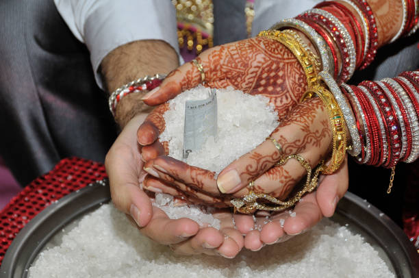 Indian couple holding hands, with their sarees tightly together, during the wedding ceremony. Concept of marriage, partnership, commitment.