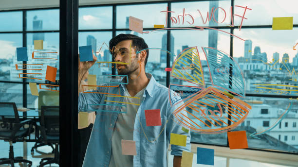 istock Businessman uses sticky notes at glass wall to brainstorming idea. Tracery 2031195072