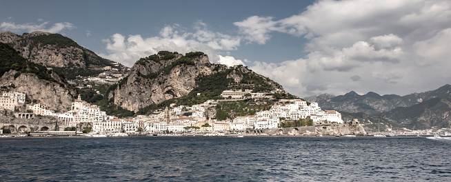 Amalfi, Italy, September 26, 2023: View from the sea of beautifully situated buildings on the slopes of the mountains in Amalfi, Campania, Italy.