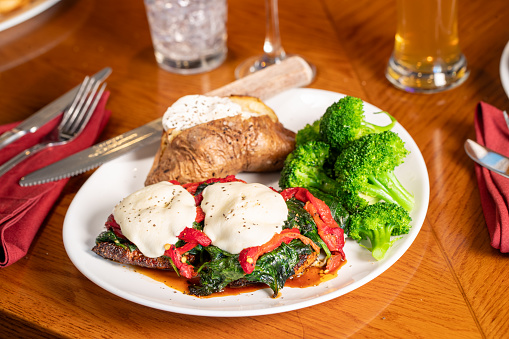 Veal topped with Spinach, Peppers and slices of mozzarella cheese, steamed broccoli and stuffed baked potato