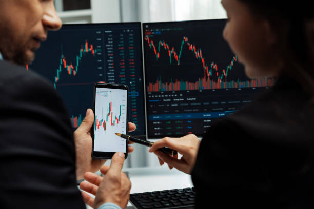 istock Focusing phone with discussing stock market in two business traders. Postulate. 2031379025