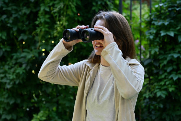 istock Young woman playing with binoculars, joyfully looking into 2031564684