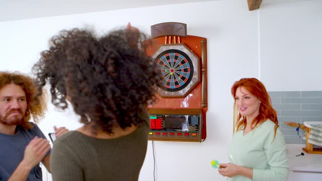 Women enjoying a casual dart game.