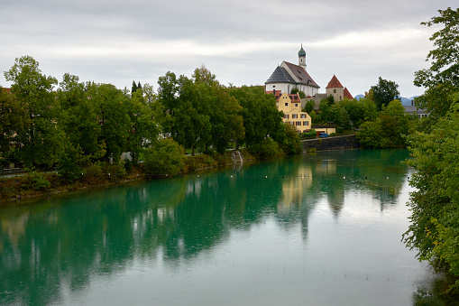 The Lech river in Fussen Bavaria, Germany and the Franciscan Monastery of St Stephen dating to the 1600s, in the background.