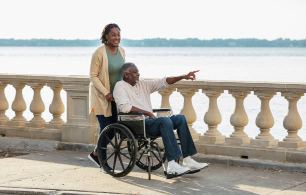 African-American senior man in wheelchair with caregiver
