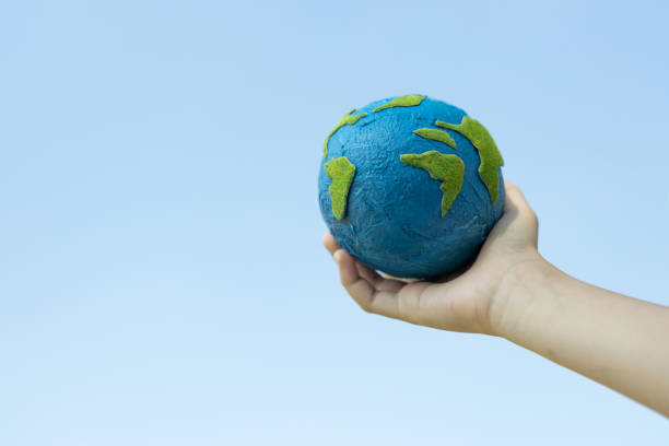 istock Young boy hand holding planet Earth globe with sky background. Gyre 2031595244
