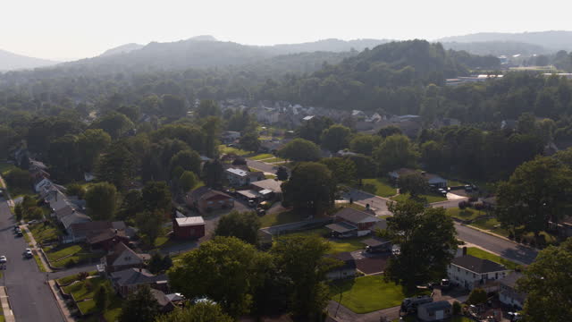 Sunny mountainous neighborhood along Delaware Ave In Palmerton, Pennsylvania. Aerial footage with backwards-panning camera motion