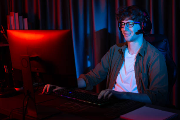 istock Smiling streamer with joystick, focusing Esport team on pc with harder. Gusher. 2031618526