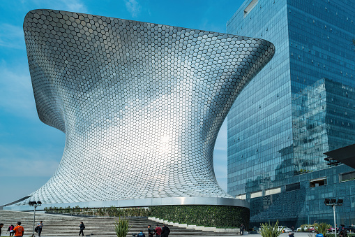 Pedestrians walk past the Museo Soumaya in the Polanco neighborhood of Mexico City on a sunny day.