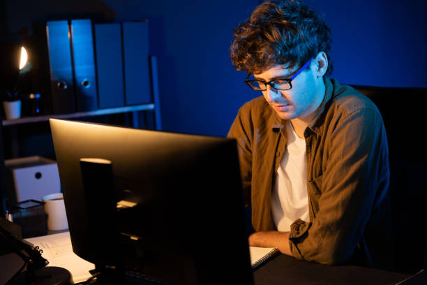 istock Businessman concentrating on pc on project at neon light office. Gusher. 2031651478