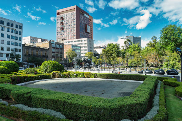 Pedestrians walk at Alameda Central park in Mexico City, Mexico on a sunny day.