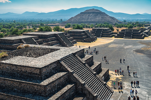 Tourists visit the Teotihuacan pyramids near Mexico City, Mexico on a sunny day, with the Pyramid of the Sun in the background.