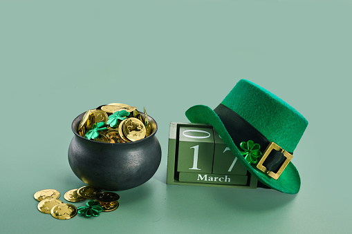 Happy St. Patrick's Day background with a leprechaun green hat full of gold coins.