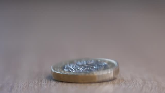 one pound coin fall in depth of field shallow focus and stop spinning
