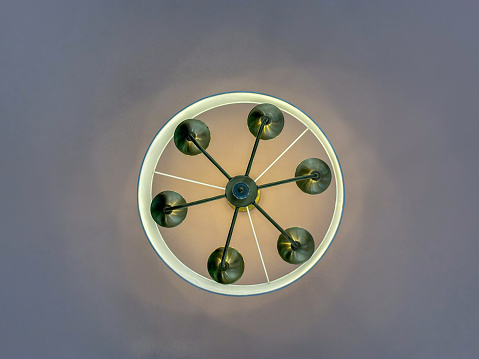 A circular light fixture with six lights attached evenly around its perimeter, illuminating the surrounding area. The lights emit a bright, uniform glow, creating a well-lit space.