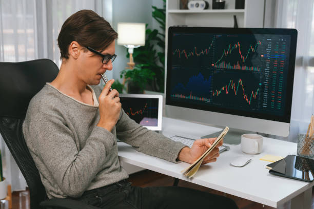 istock Trader in casual day taking note in stock exchange market graph. Pecuniary. 2031759222