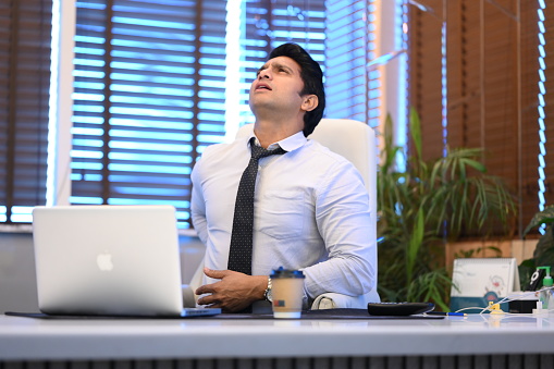 office worker suffers from back pain- stock photos
