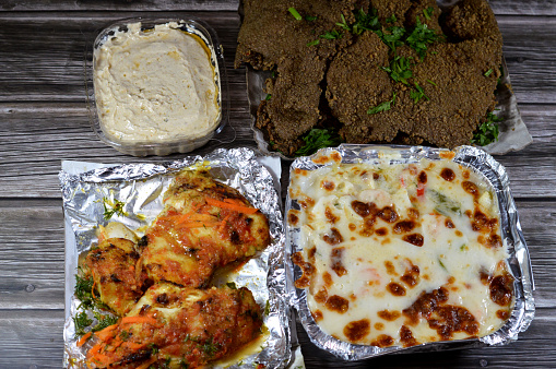 background of Arabic deep fried beef liver slices, beef liver covered with wheat bran, creamy seafood baked mix of shrimps, squid calamari, fish fillet,  mozzarella cheese, grilled fish fillet filet, selective focus