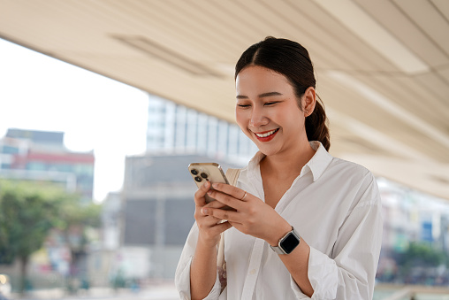 Cheerful Young woman uses a smartphone on the way to the subway