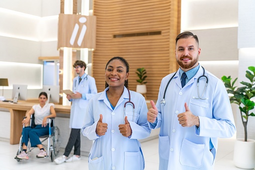 Diverse Medical Team: Black Female Doctor Gives Thumbs-Up Pose Alongside White Caucasian Male Colleague
