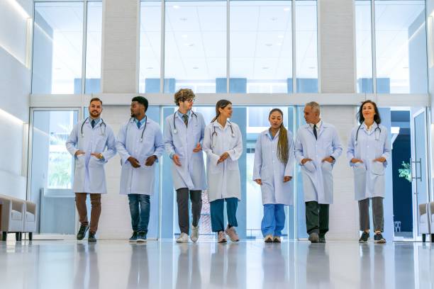 istock Diverse Medical Team: Multiracial Group of Doctors Walking Together, Engaging in Conversation with Smiles 2031985502