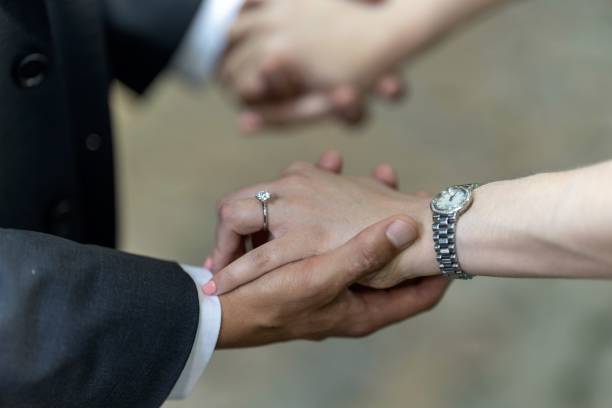 istock Couple holding hands, with a wristwatch and a diamond ring 2031989648