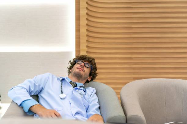 istock Restful Repose: White Doctor Caught Napping on Chair in Exhausted Respite 2032000542
