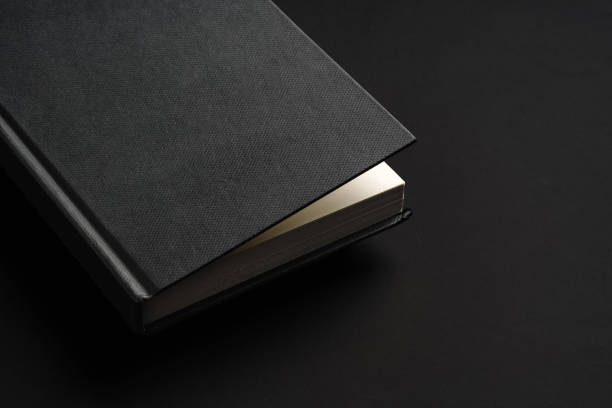 istock Black hardcover book or notepad mock up on black background 2032013509