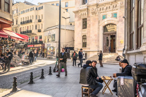 Istanbul, Turkey - February 9, 2024: Local residents enjoying Turkish tea on the street right outside the Spice Bazaar.