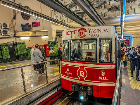 Istanbul, Turkey - February 7, 2024: Passengers arrived at Beyoglu station of the Istanbul funicular F2 line aka Tunel, a historic underground funicular railway built in 1875.