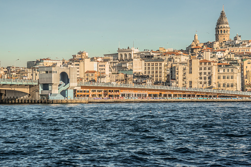 Istanbul, Turkey - February 9, 2024: Galata Bridge connects Golden Horn to Historical Peninsula. Galata Tower can be seen in the background.