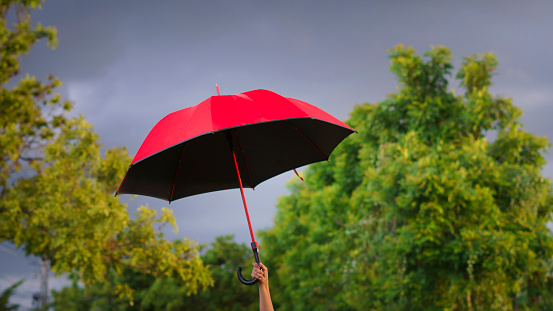 Red umbrella floating in mid-air against light blue background with copy space.