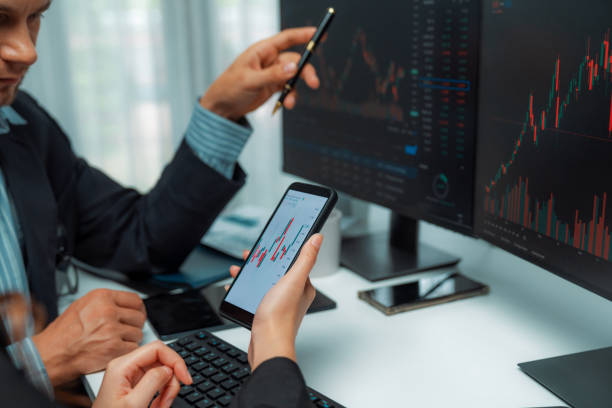 istock Focusing phone with discussing stock market in two business traders. Postulate. 2032046895