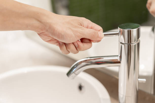 istock Save water. Man keeps turning off the running water in the bathroom to protect environment. Greening planet, reduce global warming, Save world, life, future, risk energy, crisis , water day. 2032063014