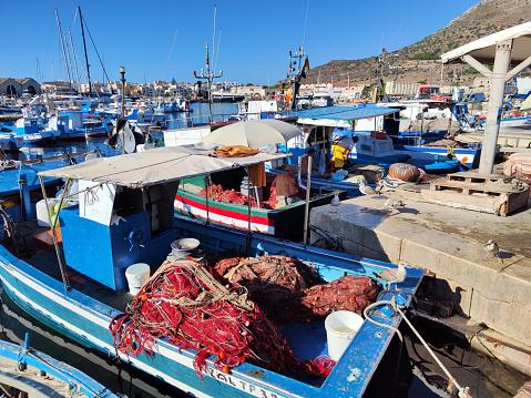 Sciacca, Sicily, Italy Jan 18, 2024  Four identical fishing boats at the dock in the old fishing port  and skyline with old houses.