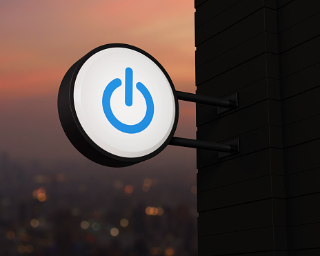 Power button icon on hanging black rounded signboard over blur of cityscape on warm light sundown, Start up business concept, 3D rendering