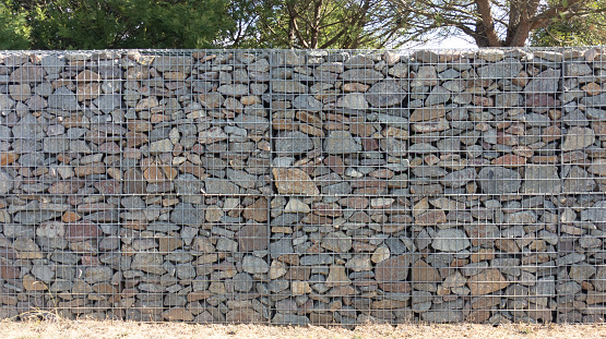 stone textured fence gabion steel metal grated stone wall basket made of mesh and stones background wall horizontal facade