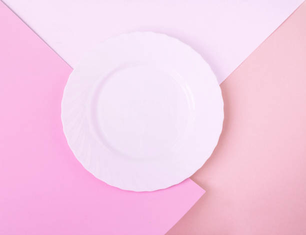istock Empty white plate for text on the pink paper background. Copy space. Top view. 2032119908