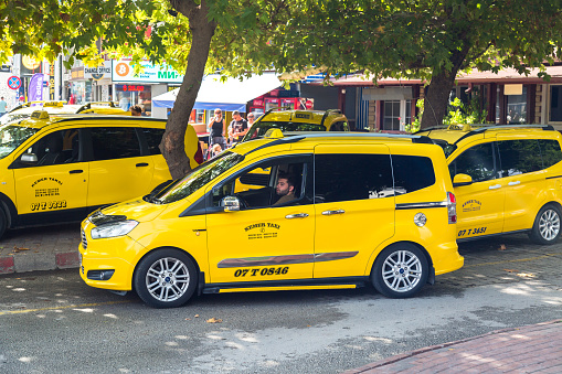 Kemer, Turkey - September 28, 2023: A group of taxi cars stand waiting for a call.