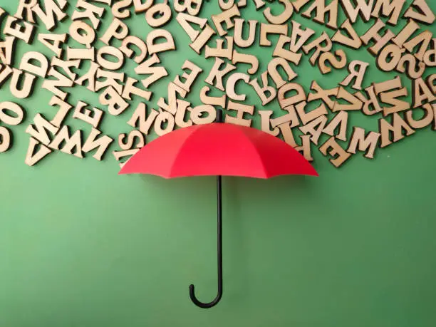Red umbrella and wooden word on a green background