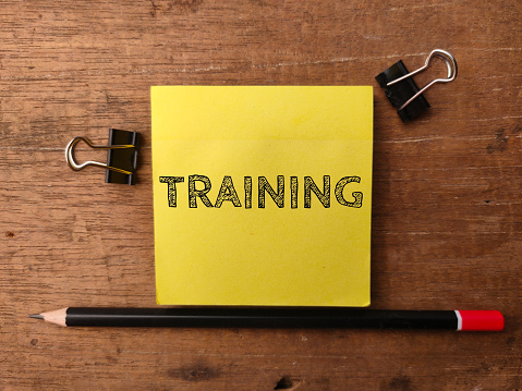 Colored note and pencil with the word TRAINING on a wooden background