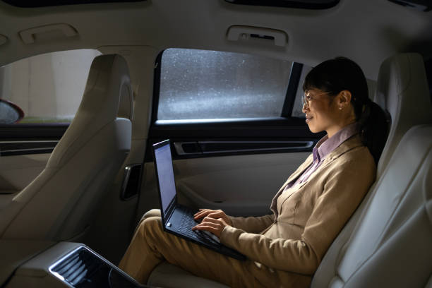 istock Businesswoman enjoying comfortable ride in luxurious limousine and working on laptop computer. 2032148607