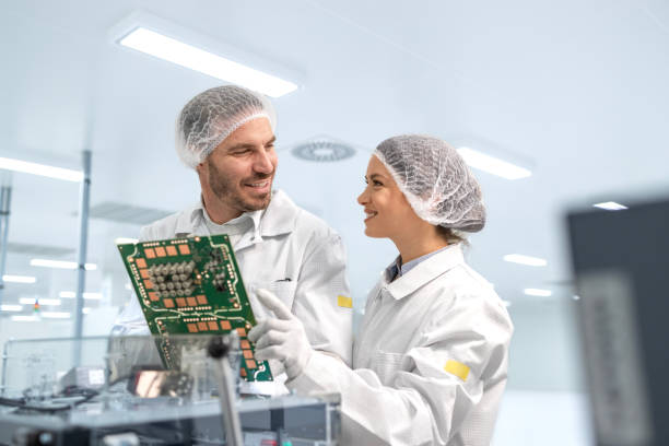 istock Experienced workers controlling quality of microchips and printed circuit boards in electronic manufacturing factory. 2032151799