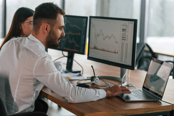 istock By the pc monitors. Two employees are working in the office together 2032158768