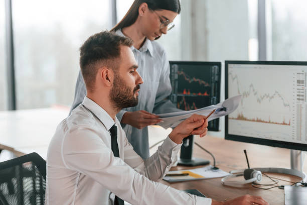 istock By the pc monitors. Two employees are working in the office together 2032159284