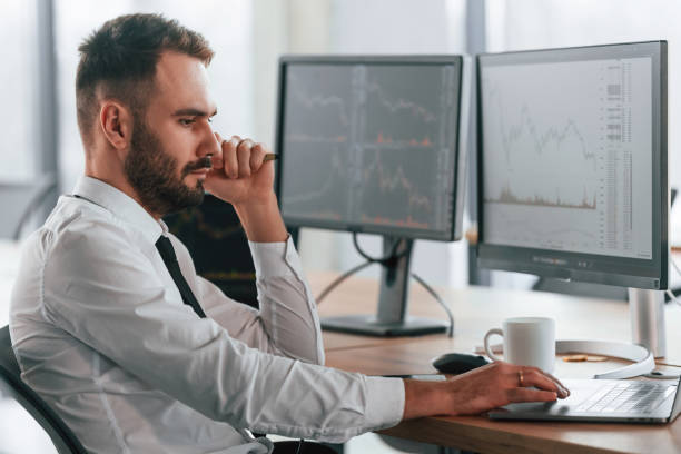 istock Side view. Businessman is sitting by computer and working in the office 2032160368